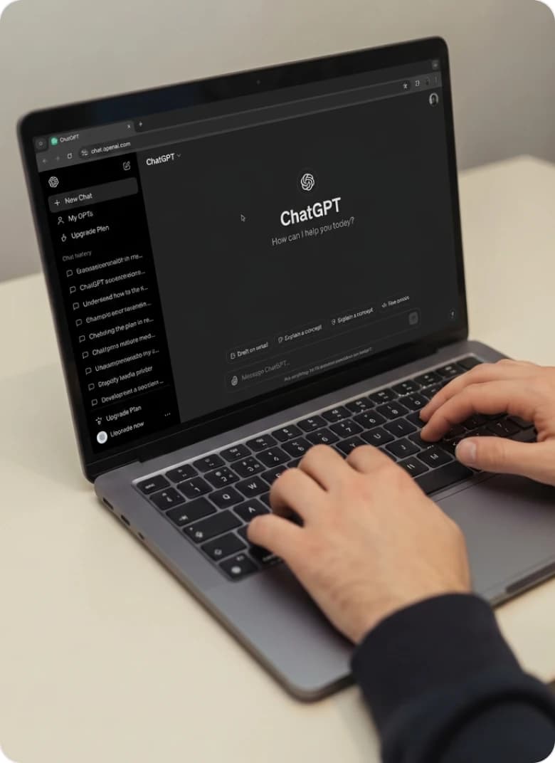 Hands typing on a laptop at a desk